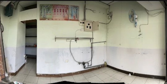 An empty, bare room with tiled floor and old wiring, before it became the nail shop